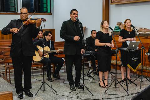 fotografia do noivo recebendo a lapela fotografia do grupo musical Cantare Casamento na igreja Santa Cruz em Rondonópolis-MT, fotografo Sergio Simões.'