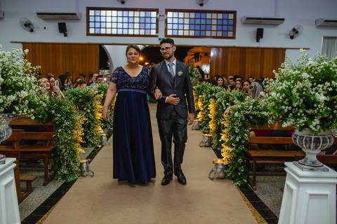 fotografia do noivo recebendo a lapela fotografia da entrada do noivo guilherme com sua mãe na igreja Santa Cruz em Rondonópolis-MT, fotografo Sergio Simões.'