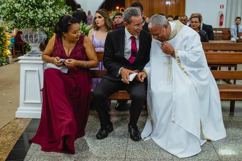 fotografia da descontração do padre no casamento de Viviane e Guilherme na igreja Santa Cruz em Rondonópolis-MT, fotografo Sergio Simões.'