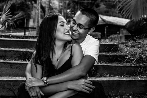 Casal de namorados sentados na escada, apaixonados e se abraçando.'