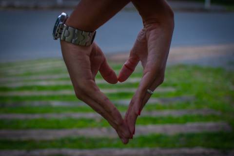Coração feito com as mãos do casal'