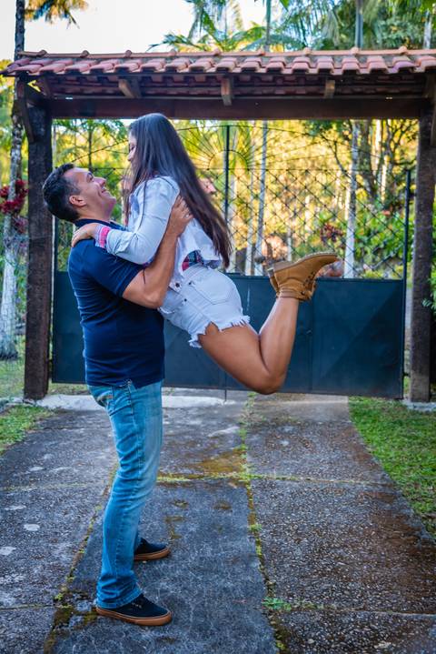 Um casal. Ele segurando ela no ar e os dois se olhando apaixonadamente.'