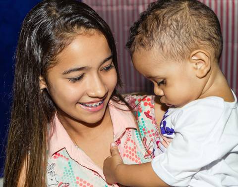 Menina sorrindo com Heitor pelo fotógrafo Douglas Maia'
