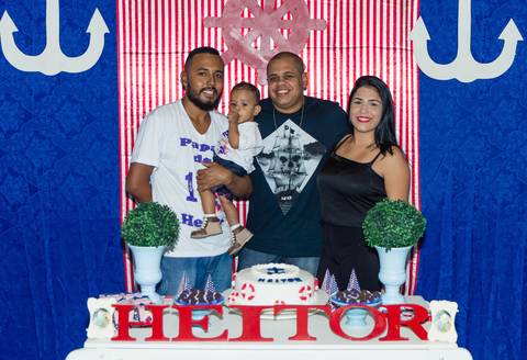 Heitor e seu pai ao lado de convidados sorridentes pelo fotógrafo Douglas Maia'