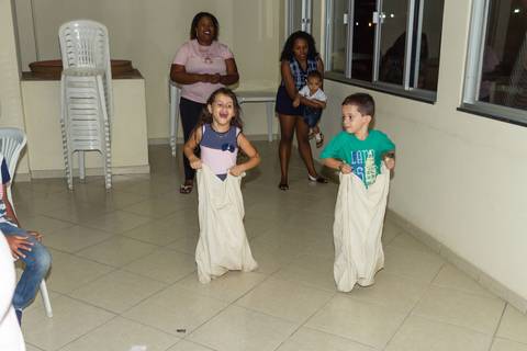 Crianças brincam de corrida de saco pelo fotógrafo Douglas Maia'
