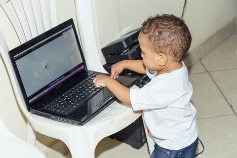 Heitor mexendo no computador pelo fotógrafo Douglas Maia'