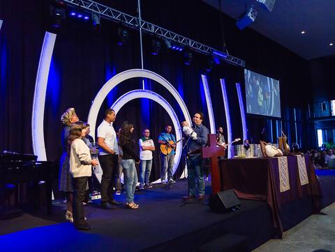 Pastor e família de criança no altar na Igreja Missão Praia da Costa pelo fotógrafo Douglas Maia'