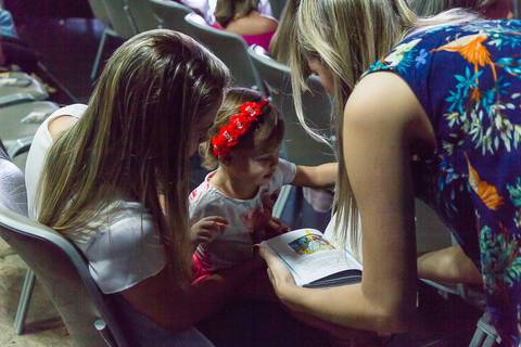 Criança lendo na Igreja Missão Praia da Costa pelo fotógrafo Douglas Maia'