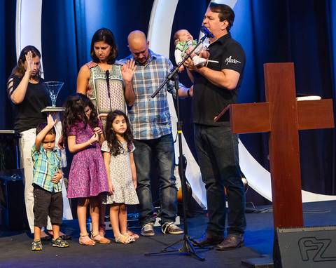 Pastor Simonton orando pela criança na Igreja Missão Praia da Costa pelo fotógrafo Douglas Maia'