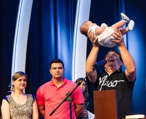 Pastor Simonton levanta a criança em apresentação a Deus na Igreja Missão Praia da Costa pelo fotógrafo Douglas Maia'