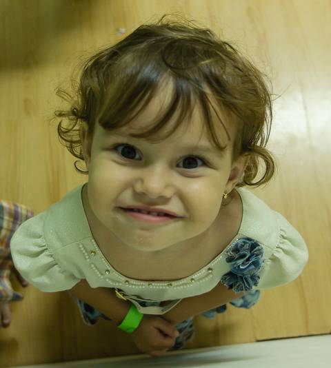 Menina feliz na salinha na Igreja Missão Praia da Costa pelo fotógrafo Douglas Maia'
