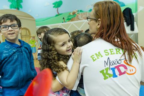 Voluntária cuidando das crianças na Igreja Missão Praia da Costa pelo fotógrafo Douglas Maia'