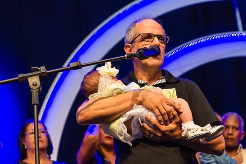 Pastor segura criança no colo na Igreja Missão Praia da Costa pelo fotógrafo Douglas Maia'
