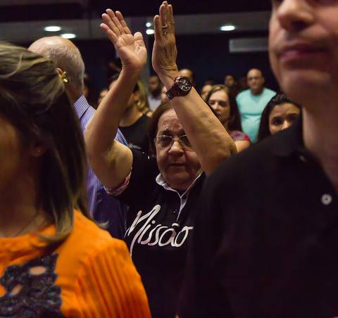 Mulher aplaude a Deus Igreja Missão Praia da Costa pelo fotógrafo Douglas Maia'