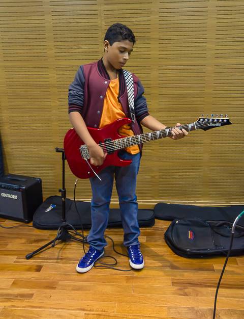 Menino tocando instrumento no culto infantil na Igreja Missão Praia da Costa pelo fotógrafo Douglas Maia'