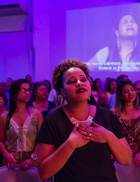 Mulher louvando a Deus na Igreja Missão Praia da Costa pelo fotógrafo Douglas Maia'