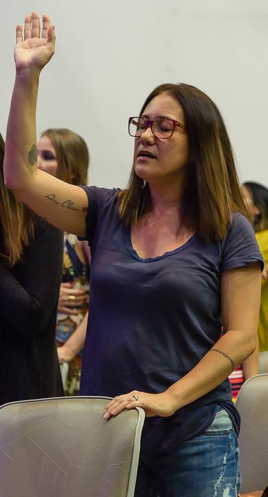 Mulher louva a Deus na Igreja Missão Praia da Costa pelo fotógrafo Douglas Maia'