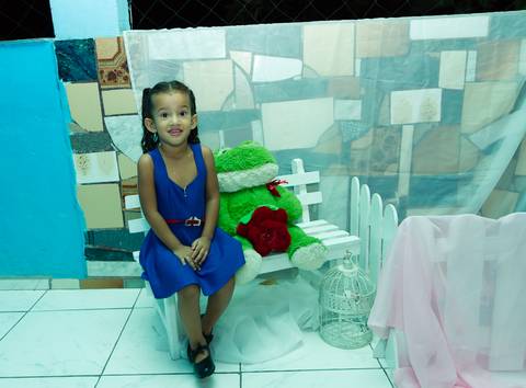 Emanuelly Victória sentada no banquinho pelo fotógrafo Douglas Maia'