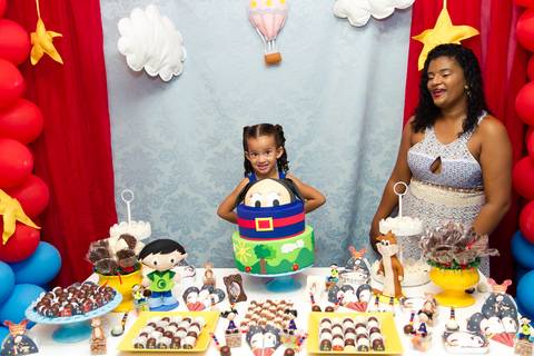 Manu ao lado do bolo pelo fotógrafo Douglas Maia'