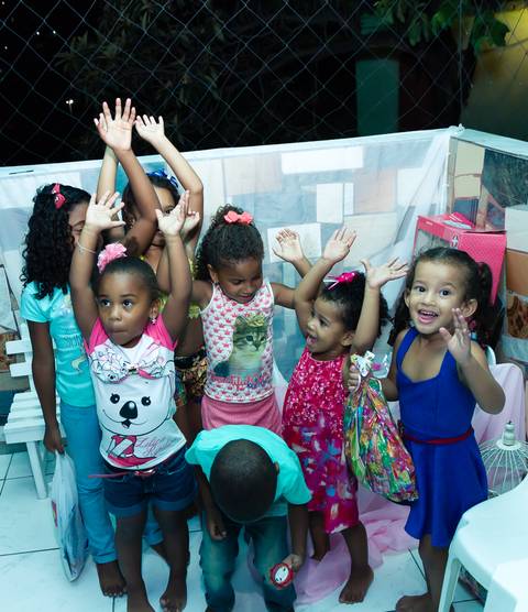 Crianças com braços levantados pelo fotógrafo Douglas Maia'