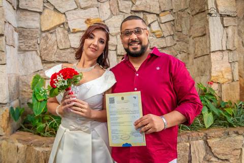 noivos carregando a certidão de casamento'