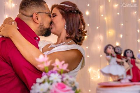 decoração do bolo com os noivos em foco se beijando de fundo'