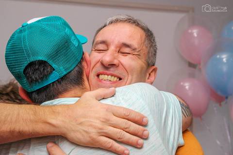 pai feliz abraçando convidado'