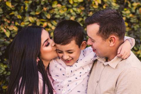 Retrato de Filho abraçando os pais e recebendo beijo da mãe.'