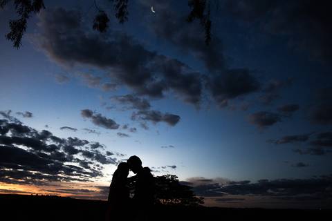 casal ao por do sol abraçados em ensaio de gestante'