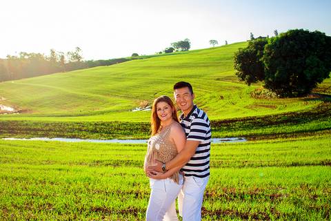 casal posando para ensaio de gestante em campo verde na zona rural de mandaguari em ensaio de gestante'
