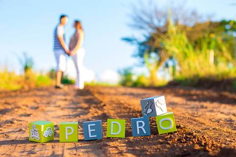 casal posando ao fundo com o nome do filho a frente em ensaio de gestante na zona rural de mandaguari na regiao de maringa'
