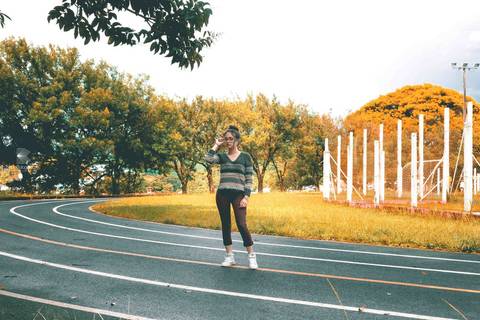 Garota posando para foto em pista de corrida'