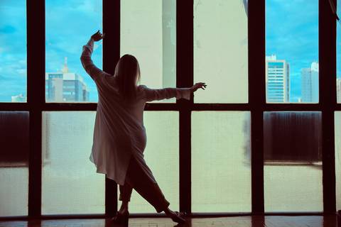 mulher dançando na janela'