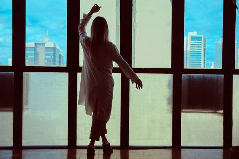 bailarina dançando com paisagem de cidade ao fundo'