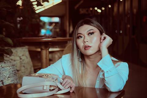 mulher pensativa em mesa de restaurante'