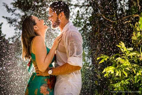 foto expontânea e criativa na chuva de  uma noiva grávida em um ensaio realizando no chalé da zuzu em mosqueiro PA fotografado pelo romulo silva fotografias'
