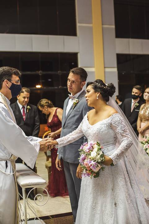 padre celebra cerimonia religiosa de casamento'