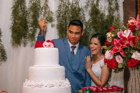Noivos zoando na hora de cortar o bolo'
