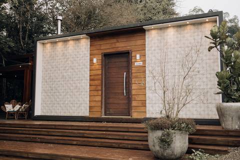 Fachada moderna de local para casamento com revestimento em madeira e iluminação decorativa - Alba Estúdio Lajeado