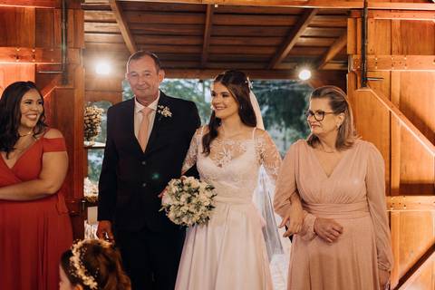 Noiva entrando no salão com os pais no casamento em Lajeado na Casa Irmando, registro por Alba Estúdio.'