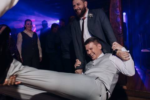 Noivo sendo arrastado e rindo na pista de dança, em momento descontraído do casamento na Casa Irmando, em Lajeado. Foto de Alba Estúdio.'