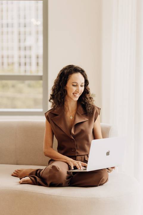 Psicóloga em ensaio de posicionamento digital, trabalhando no notebook em cenário minimalista do estúdio em Lajeado – Alba Estúdio.'