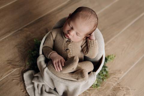 Ensaio newborn em Lajeado – recém-nascido em balde branco, com macacão bege de tricô, fotografia feita pelo Alba Estúdio.'
