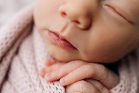 Close newborn – detalhe da boca e das mãozinhas do bebê dormindo, fotografia feita em Lajeado pelo Alba Estúdio.'