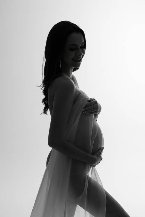 Retrato artístico de gestante de perfil, com luz lateral e composição minimalista que evidencia a beleza da maternidade. Alba Estúdio Fotográfico, Lajeado, RS.'