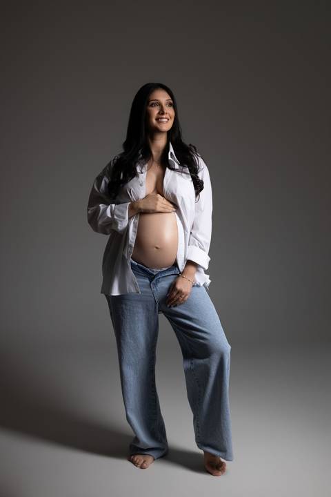 Ensaio gestante em estúdio com look casual de camisa branca e jeans, valorizando a beleza e a naturalidade da maternidade. Fotografia do Alba Estúdio em Lajeado, RS.'