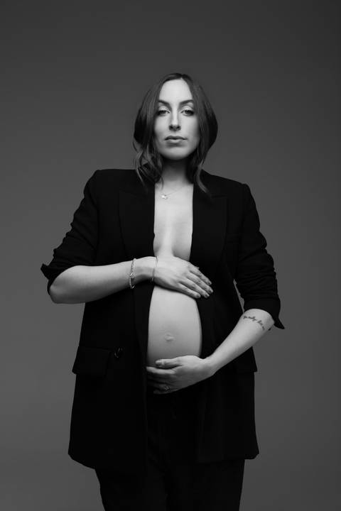 Retrato feminino em preto e branco durante ensaio gestante, com blazer preto e composição editorial que valoriza força e elegância. Fotografia do Alba Estúdio em Lajeado, RS.'