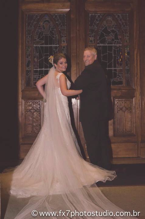 Noiva e pai de costas na porta da igreja aguardando'