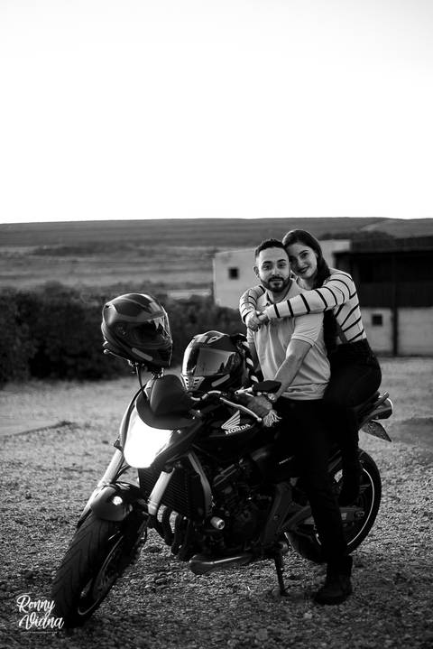 Retrato do casal em cima da Moto Hornet da Honda noiva abrancando o noivo com blusa de Frio '