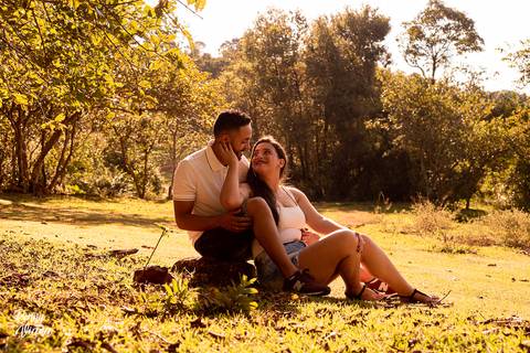 Casal sentado em baixo da arvore namorando com roupas brancas e neutra ensaio pre wedding'